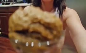 Dark haired teen shits in a glass